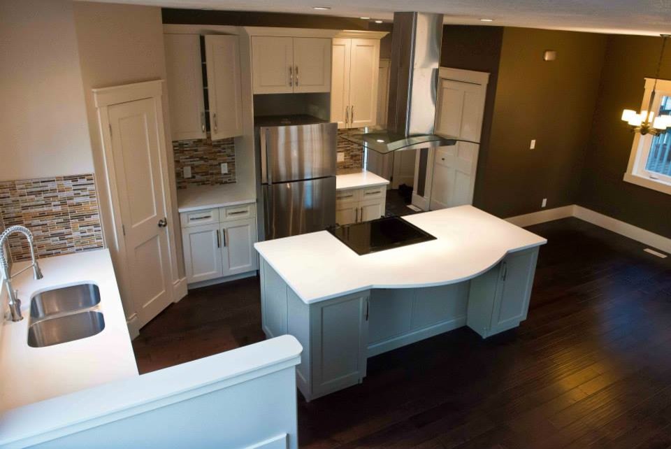 Kitchen pantry - transitional l-shaped dark wood floor kitchen pantry idea in Edmonton with an undermount sink, shaker cabinets, white cabinets, concrete countertops, multicolored backsplash, matchstick tile backsplash, stainless steel appliances and an island