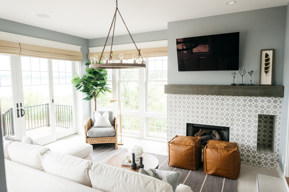 Design ideas for a mid-sized country enclosed family room in Detroit with grey walls, ceramic floors, a standard fireplace, a tile fireplace surround, a wall-mounted tv and grey floor.