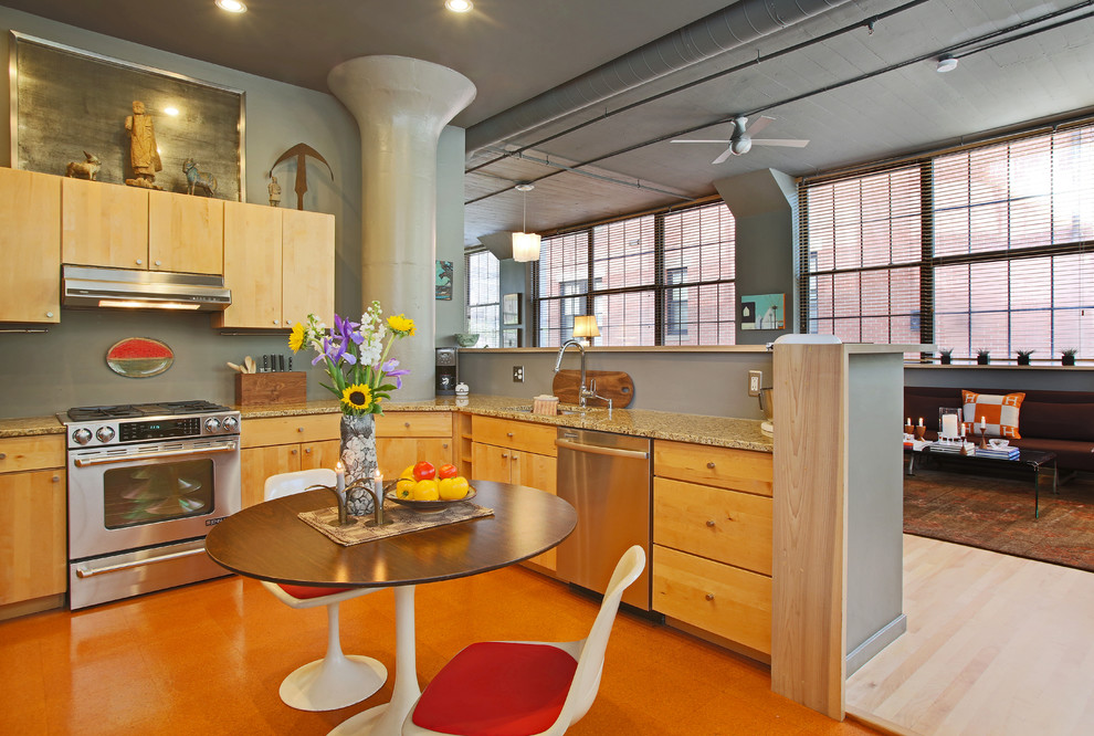 Photo of an industrial open plan kitchen in Boston with an undermount sink, stainless steel appliances, granite benchtops, light wood cabinets, flat-panel cabinets and no island.