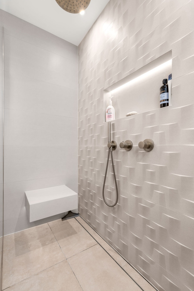 Photo of a medium sized contemporary ensuite bathroom in Berkshire with flat-panel cabinets, brown cabinets, a walk-in shower, a wall mounted toilet, beige tiles, ceramic tiles, beige walls, porcelain flooring, a built-in sink, solid surface worktops, beige floors, an open shower, white worktops, a feature wall, a single sink and a floating vanity unit.