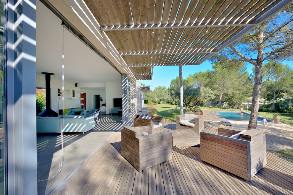 Inspiration for a large contemporary front yard patio in Montpellier with a pergola and decking.