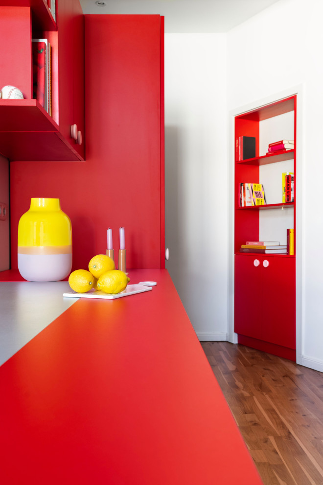 Réalisation d'une cuisine minimaliste de taille moyenne avec un placard à porte plane, des portes de placard rouges et un plan de travail rouge.