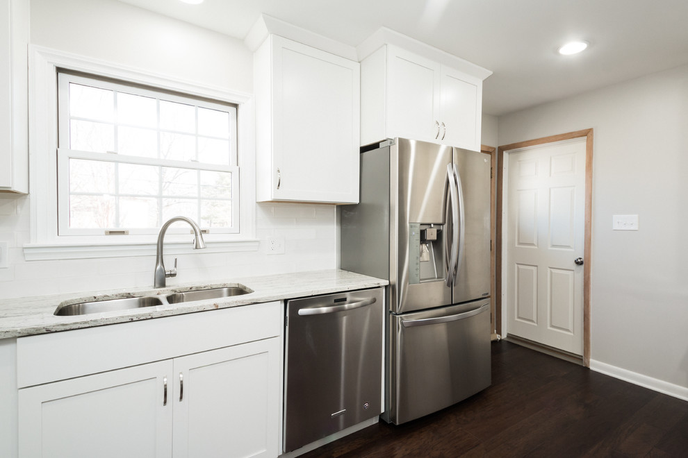 Inspiration for a mid-sized transitional u-shaped eat-in kitchen in Columbus with an undermount sink, shaker cabinets, white cabinets, granite benchtops, white splashback, subway tile splashback and stainless steel appliances.