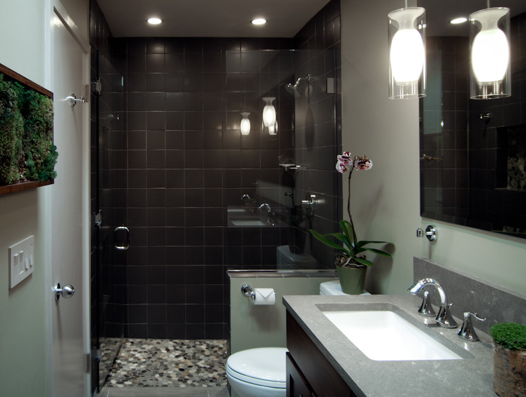 Photo of a mid-sized contemporary master bathroom in Chicago with recessed-panel cabinets, dark wood cabinets, an alcove shower, multi-coloured tile, pebble tile, grey walls, porcelain floors, an undermount sink and engineered quartz benchtops.
