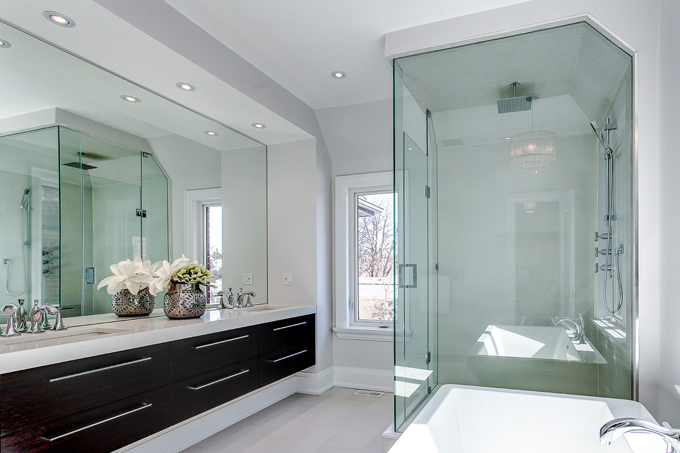 Inspiration for a transitional bathroom in Toronto with an undermount sink, flat-panel cabinets, dark wood cabinets, a freestanding tub, a corner shower and grey walls.