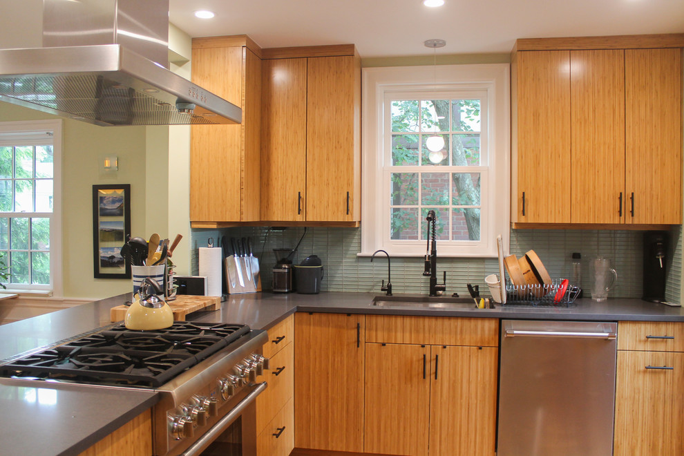 This is an example of a mid-sized transitional l-shaped kitchen in Boston with light wood cabinets, blue splashback, glass tile splashback, stainless steel appliances, a peninsula, grey benchtop, an undermount sink, flat-panel cabinets and quartz benchtops.