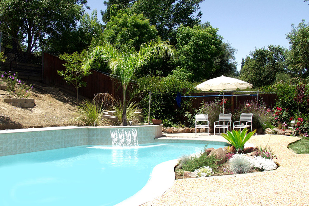 This is an example of a large traditional backyard custom-shaped lap pool in San Francisco with a water feature and decomposed granite.