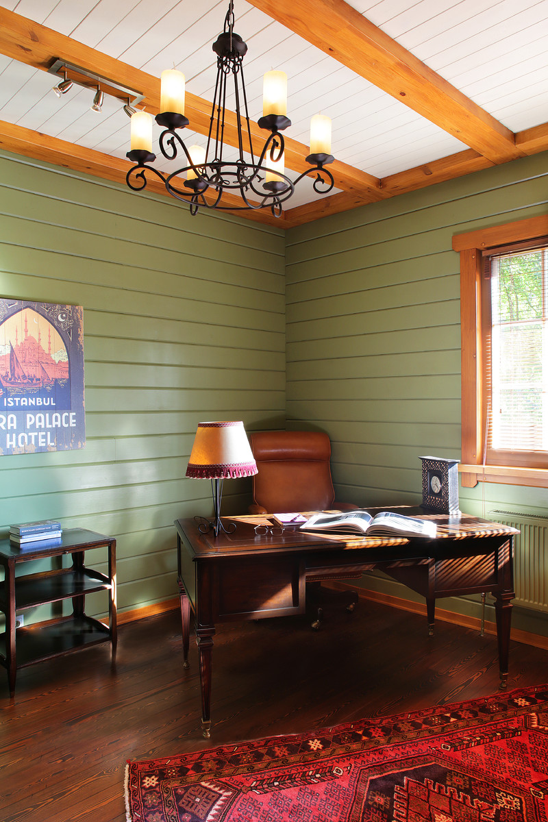 Photo of a country study room in Moscow with green walls, dark hardwood floors, a freestanding desk and brown floor.