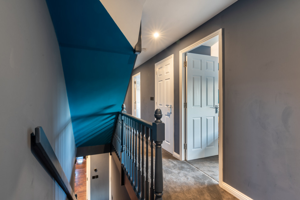 На фото: коридор среднего размера: освещение в современном стиле с синими стенами, ковровым покрытием и серым полом