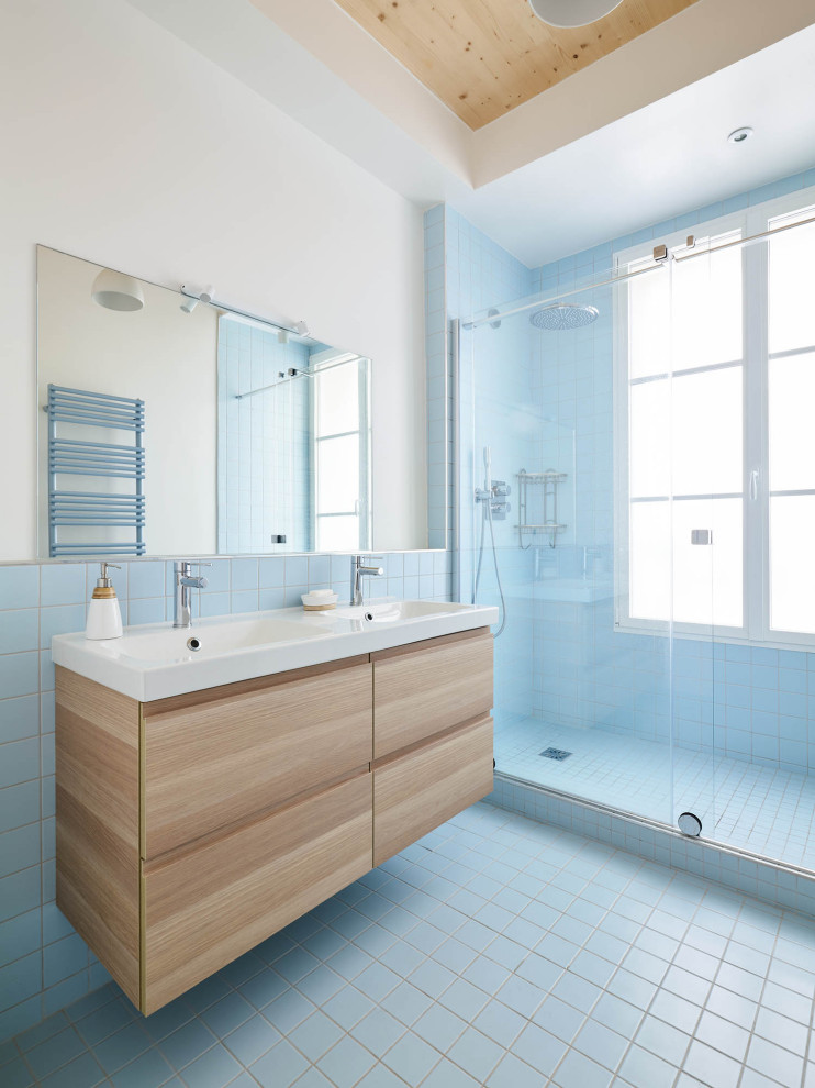 Medium sized contemporary family bathroom in Paris with light wood cabinets, a built-in shower, blue tiles, ceramic tiles, blue walls, ceramic flooring, blue floors, a hinged door, double sinks, a floating vanity unit and a wood ceiling.