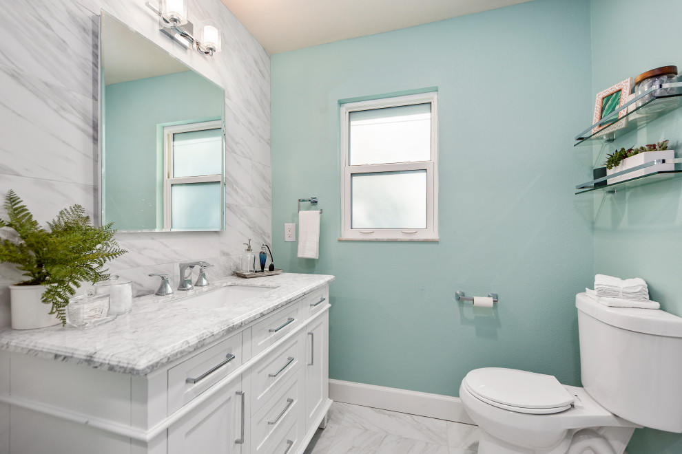 Foto på ett litet maritimt vit en-suite badrum, med skåp i shakerstil, vita skåp, en öppen dusch, en toalettstol med hel cisternkåpa, vit kakel, porslinskakel, gröna väggar, klinkergolv i porslin, ett undermonterad handfat, marmorbänkskiva, vitt golv och dusch med duschdraperi