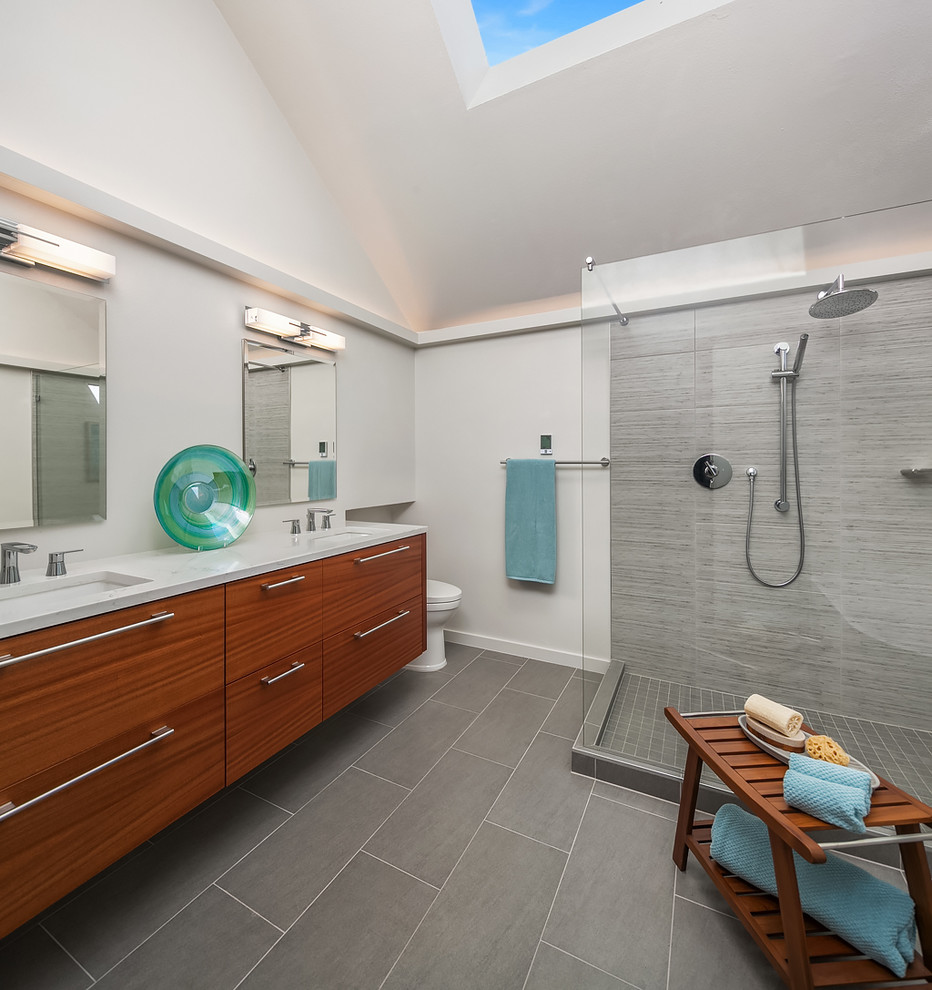 Design ideas for a contemporary master bathroom in Seattle with flat-panel cabinets, medium wood cabinets, a freestanding tub, gray tile, porcelain tile, porcelain floors, an undermount sink, engineered quartz benchtops, grey floor, an open shower, a corner shower and white walls.
