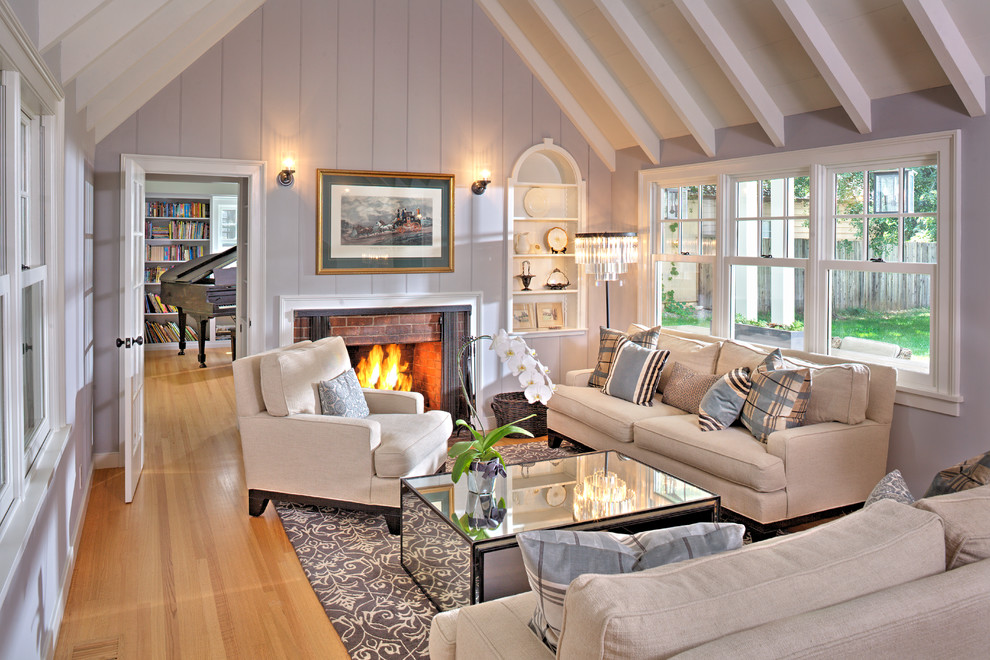 Design ideas for a country family room in Sacramento with purple walls, medium hardwood floors, a standard fireplace, a brick fireplace surround and brown floor.