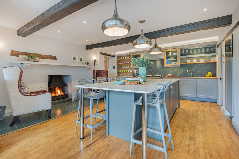 Inspiration for a country l-shaped kitchen in Other with recessed-panel cabinets, grey cabinets, wood worktops, medium hardwood flooring, an island, brown floors, brown worktops and exposed beams.