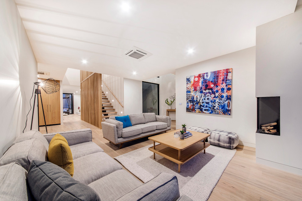 Photo of a contemporary open concept living room in Canberra - Queanbeyan with white walls, light hardwood floors, a corner fireplace and no tv.