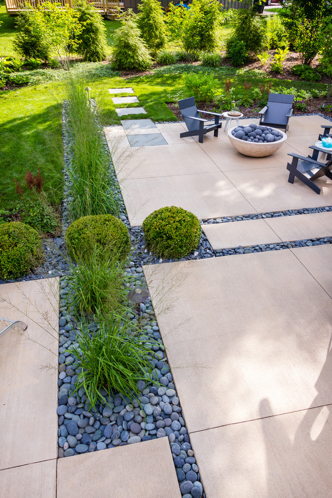 Photo of a mid-sized modern backyard patio in Milwaukee with a fire feature and concrete slab.