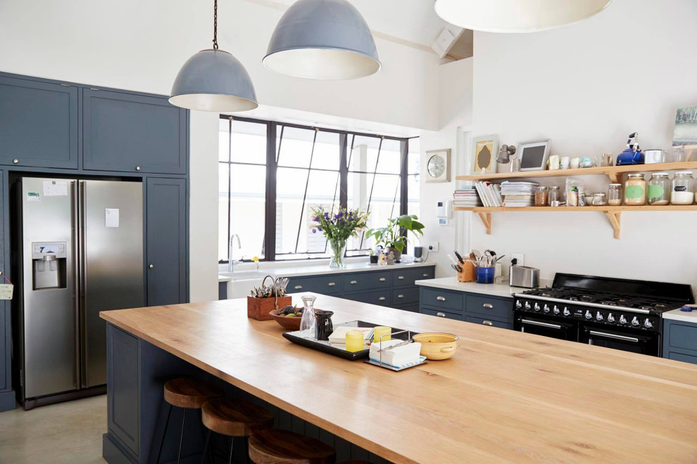 Mid-sized l-shaped eat-in kitchen in Los Angeles with a drop-in sink, flat-panel cabinets, grey cabinets, wood benchtops, white splashback, marble splashback, black appliances, light hardwood floors, with island, multi-coloured floor, multi-coloured benchtop and coffered.