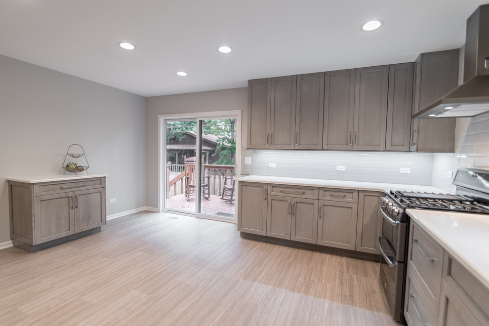 Example of a mid-sized transitional u-shaped vinyl floor and gray floor enclosed kitchen design in Chicago with an undermount sink, recessed-panel cabinets, gray cabinets, quartzite countertops, gray backsplash, subway tile backsplash and stainless steel appliances