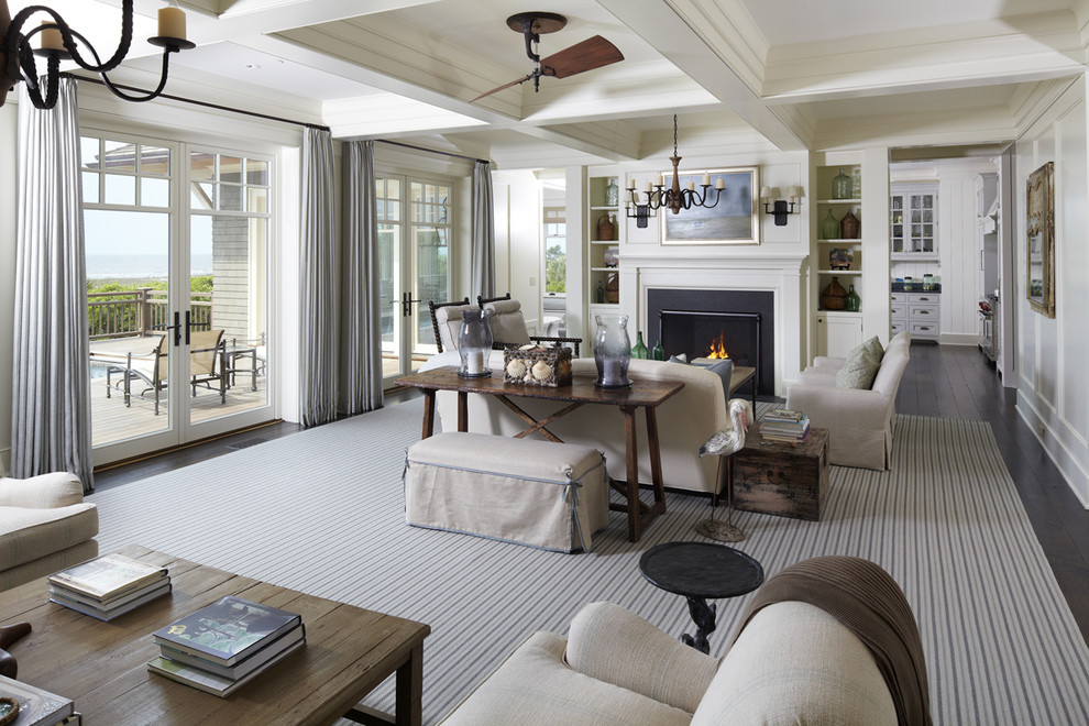 Design ideas for a beach style living room in Charleston with white walls and a standard fireplace.