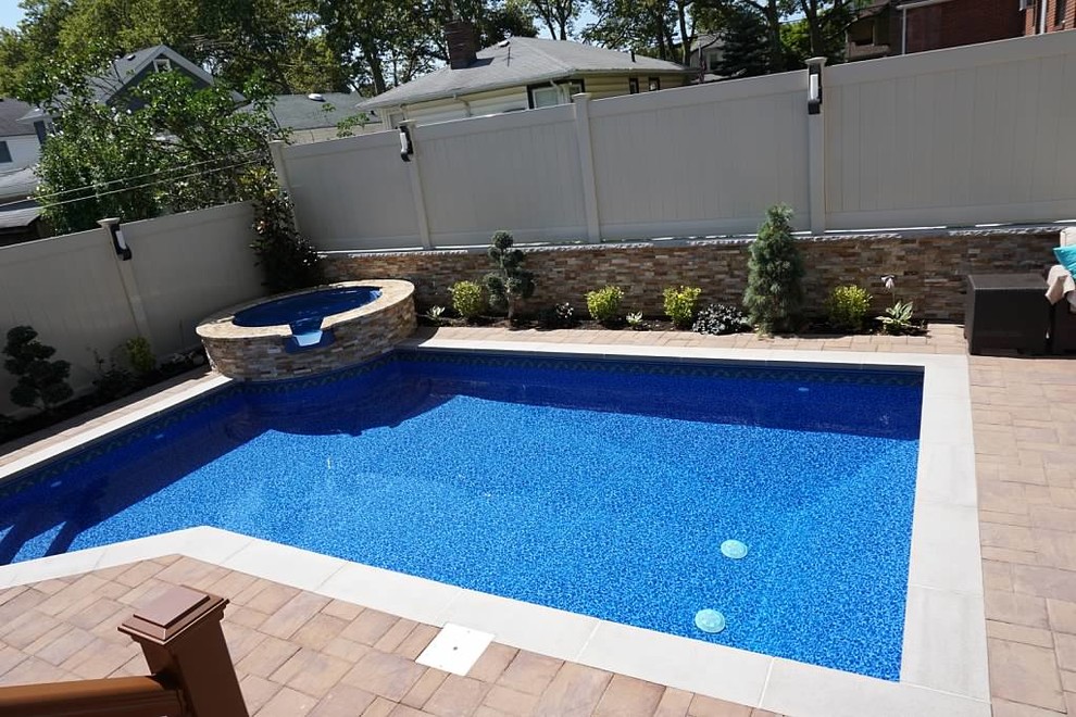 Hot tub - mid-sized transitional backyard stone and custom-shaped natural hot tub idea in New York