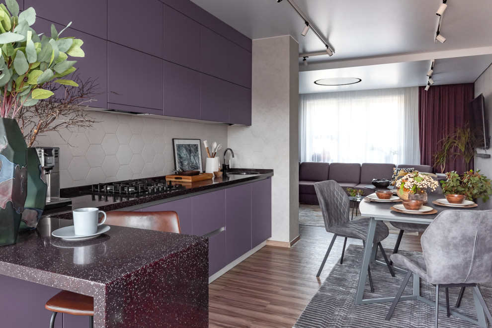 Photo of a medium sized contemporary l-shaped kitchen/diner in Other with a submerged sink, flat-panel cabinets, purple cabinets, terrazzo worktops, grey splashback, ceramic splashback, black appliances, vinyl flooring, no island, brown floors and black worktops.