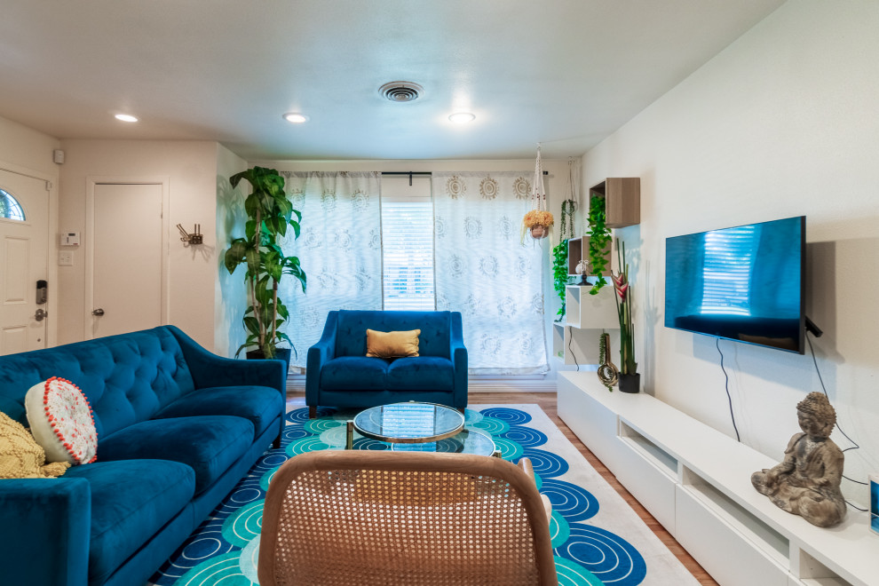 Diseño de salón abierto bohemio de tamaño medio con paredes multicolor, suelo de madera en tonos medios, televisor colgado en la pared y suelo marrón