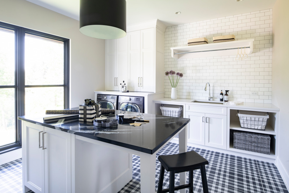 Photo of a transitional galley kitchen in Minneapolis with an undermount sink, recessed-panel cabinets, white cabinets, white splashback, subway tile splashback, black floor and white benchtop.