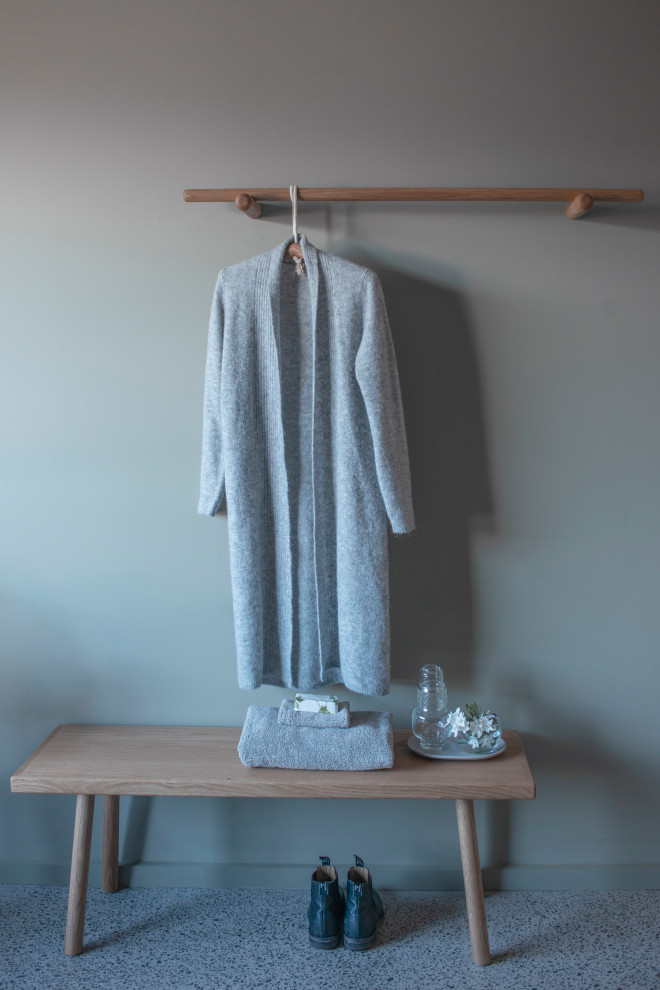 This is an example of a small contemporary gender-neutral storage and wardrobe in Melbourne with open cabinets, medium wood cabinets, concrete floors and grey floor.