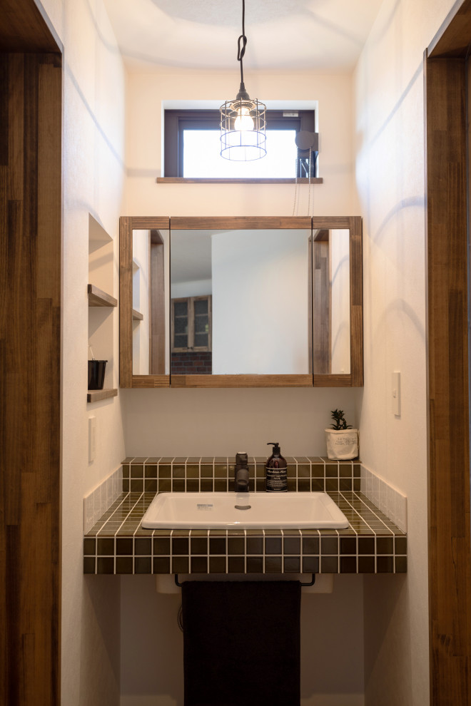 Идея дизайна: туалет в скандинавском стиле с белыми фасадами, коричневой плиткой, керамогранитной плиткой и коричневой столешницей