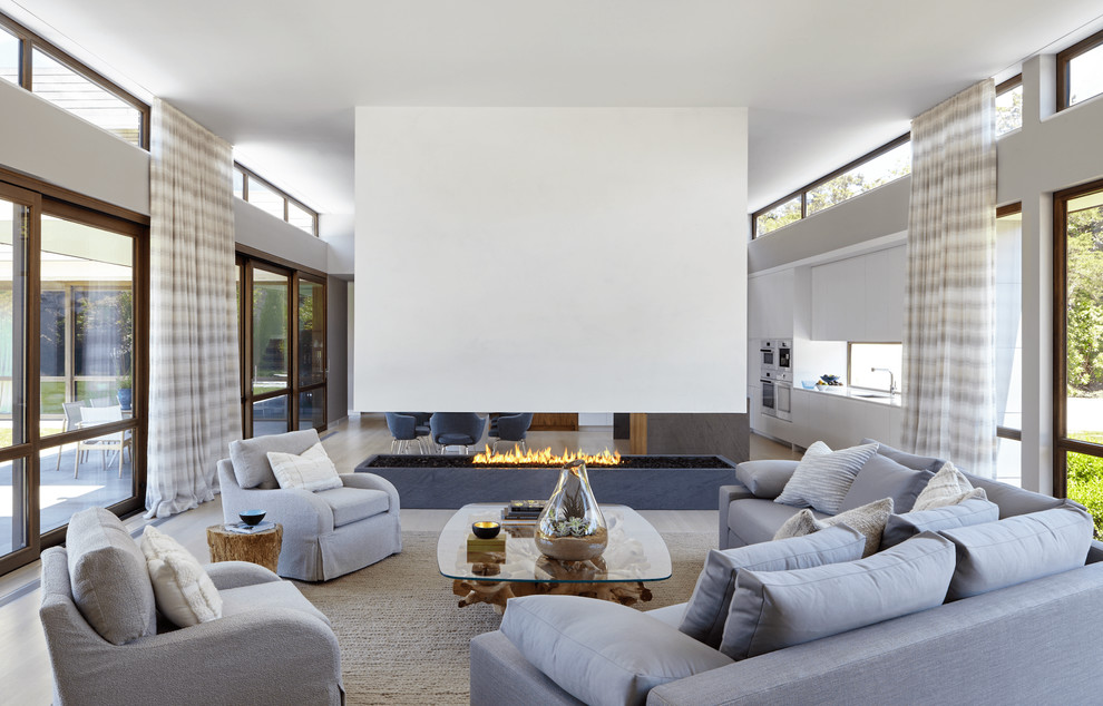 Inspiration for a beach style formal living room in New York with white walls and a two-sided fireplace.
