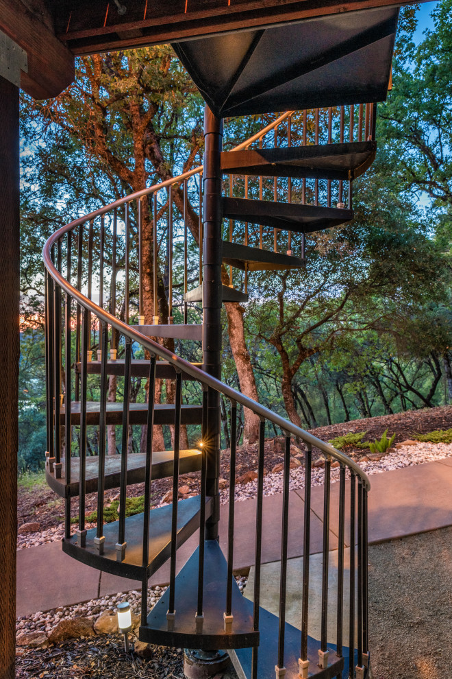 This is an example of a mid-sized arts and crafts backyard and first floor deck in Sacramento with a pergola and metal railing.