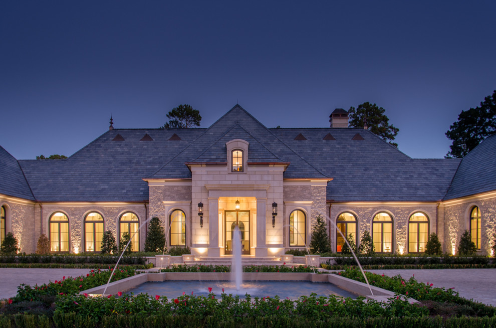 Expansive mediterranean beige exterior in Houston with stone veneer and a gable roof.