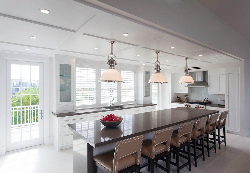 Beach style l-shaped kitchen in Boston with shaker cabinets, white cabinets, stainless steel appliances, an undermount sink, grey splashback and with island.