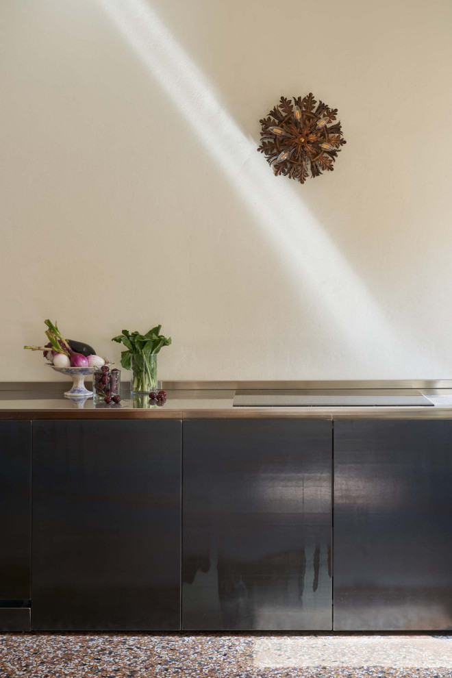 ボローニャにあるトラディショナルスタイルのおしゃれなキッチン (一体型シンク、ステンレスカウンター、パネルと同色の調理設備、テラゾーの床、オレンジの床) の写真
