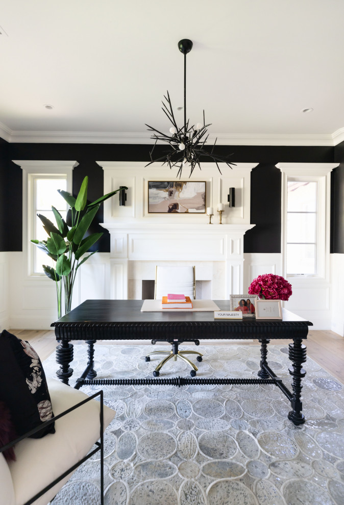 Modern home office in Phoenix with black walls, a standard fireplace and a freestanding desk.
