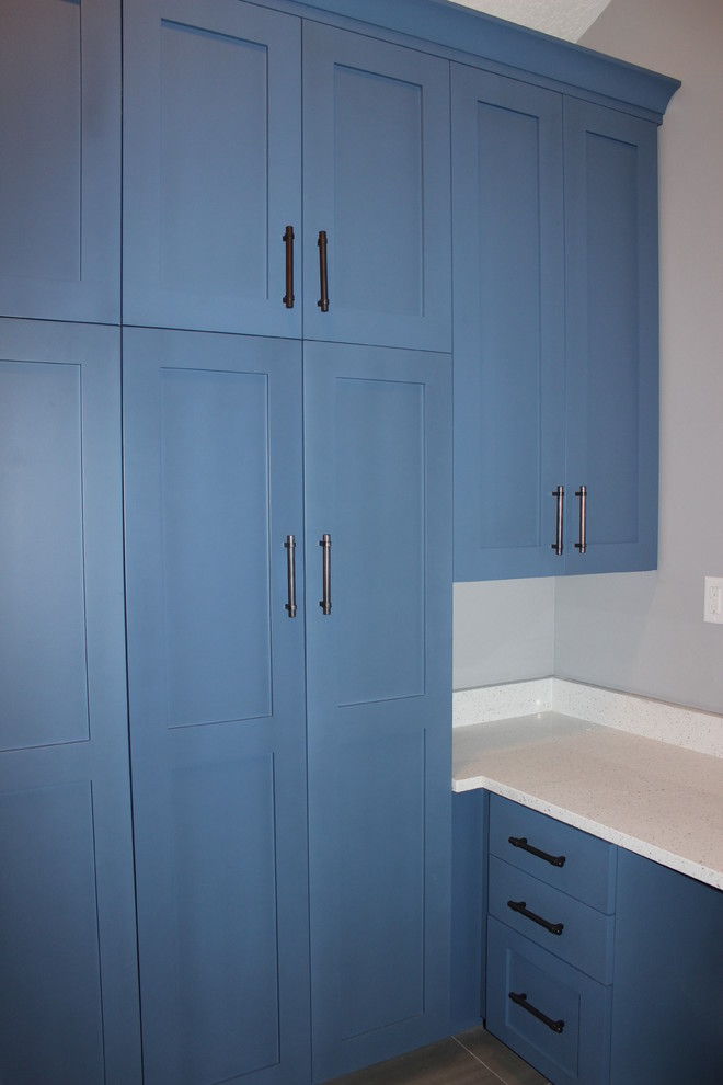 This is an example of a large arts and crafts u-shaped utility room in Salt Lake City with raised-panel cabinets, grey cabinets, granite benchtops, grey walls, ceramic floors, a side-by-side washer and dryer and an undermount sink.