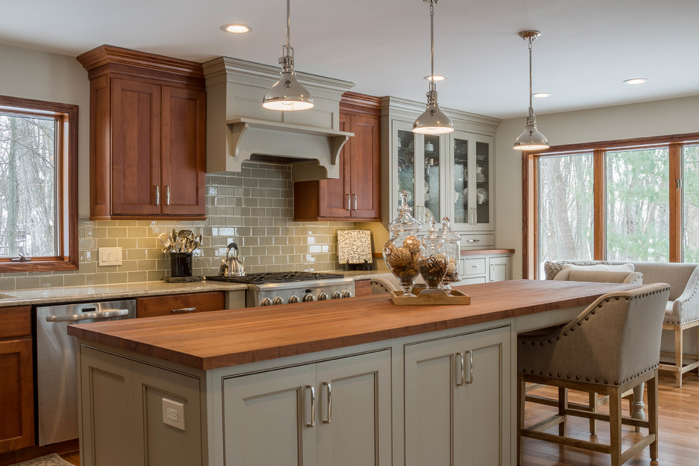 Inspiration for a large traditional l-shaped eat-in kitchen in Detroit with an undermount sink, shaker cabinets, green cabinets, wood benchtops, green splashback, glass tile splashback, stainless steel appliances, medium hardwood floors, with island and brown floor.