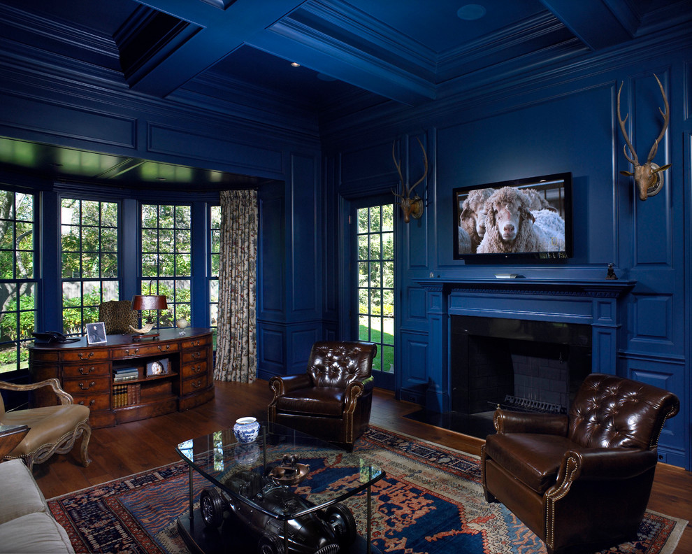 This is an example of a living room in Detroit with blue walls, a standard fireplace, a wood fireplace surround and a wall-mounted tv.