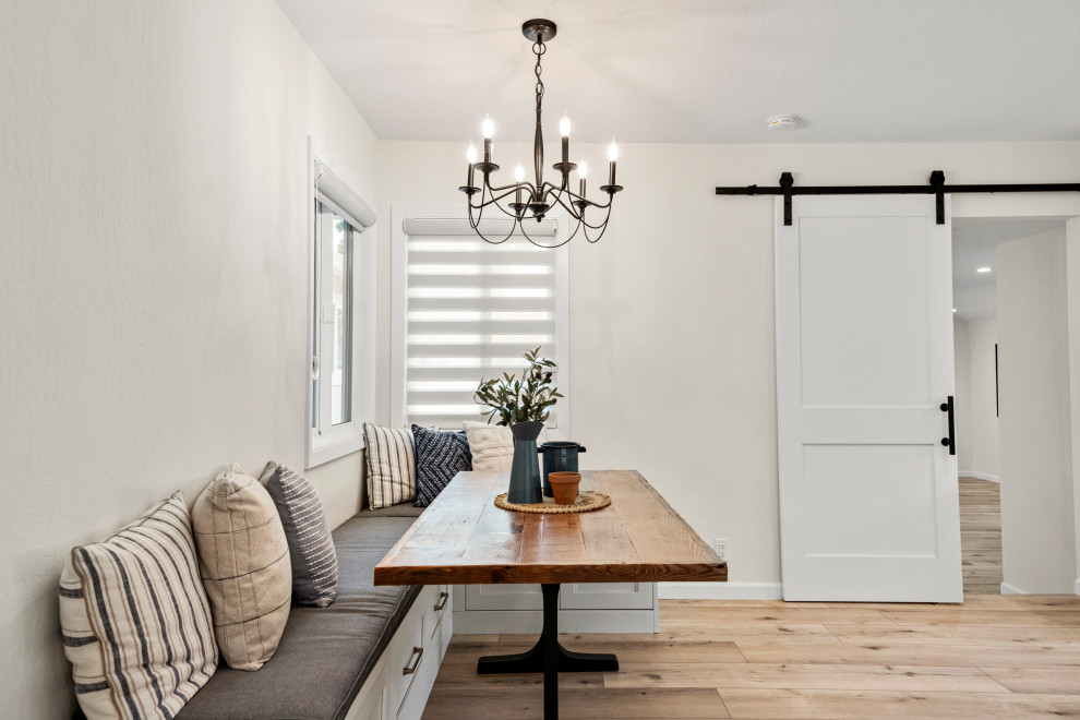 Esempio di un grande angolo colazione stile americano con pareti bianche, pavimento in vinile e pavimento marrone