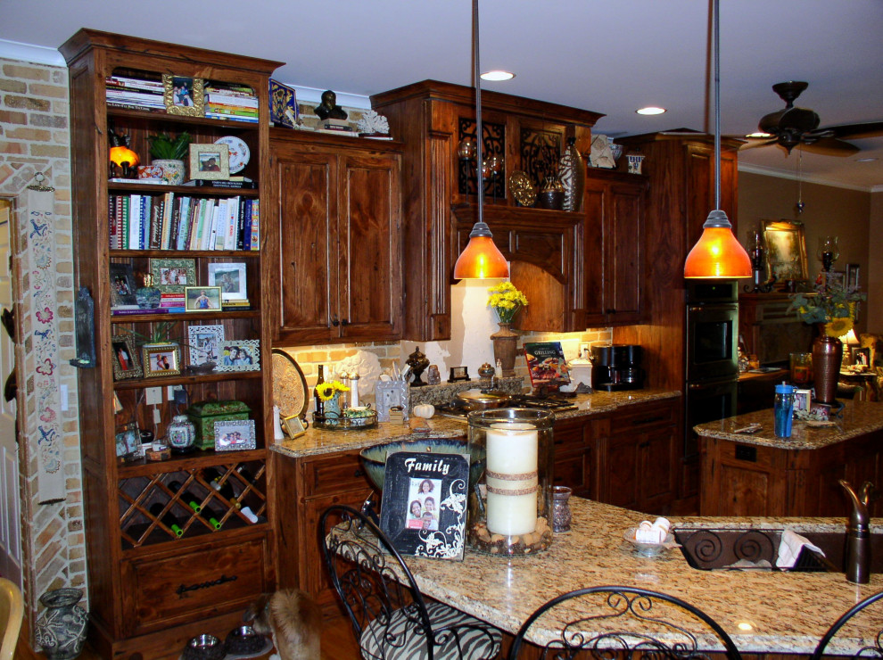 Inspiration for a mid-sized galley medium tone wood floor and brown floor kitchen remodel in Atlanta with an undermount sink, raised-panel cabinets, medium tone wood cabinets, granite countertops, stainless steel appliances, an island and multicolored countertops