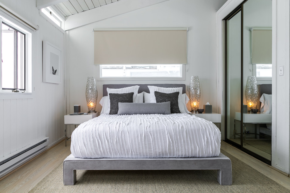Photo of a small beach style guest bedroom in Los Angeles with white walls, light hardwood floors and no fireplace.
