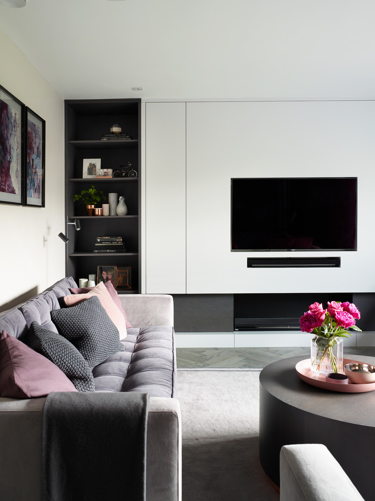 This is an example of a mid-sized contemporary formal enclosed living room in Surrey with grey walls, medium hardwood floors, a ribbon fireplace, a wood fireplace surround and a built-in media wall.