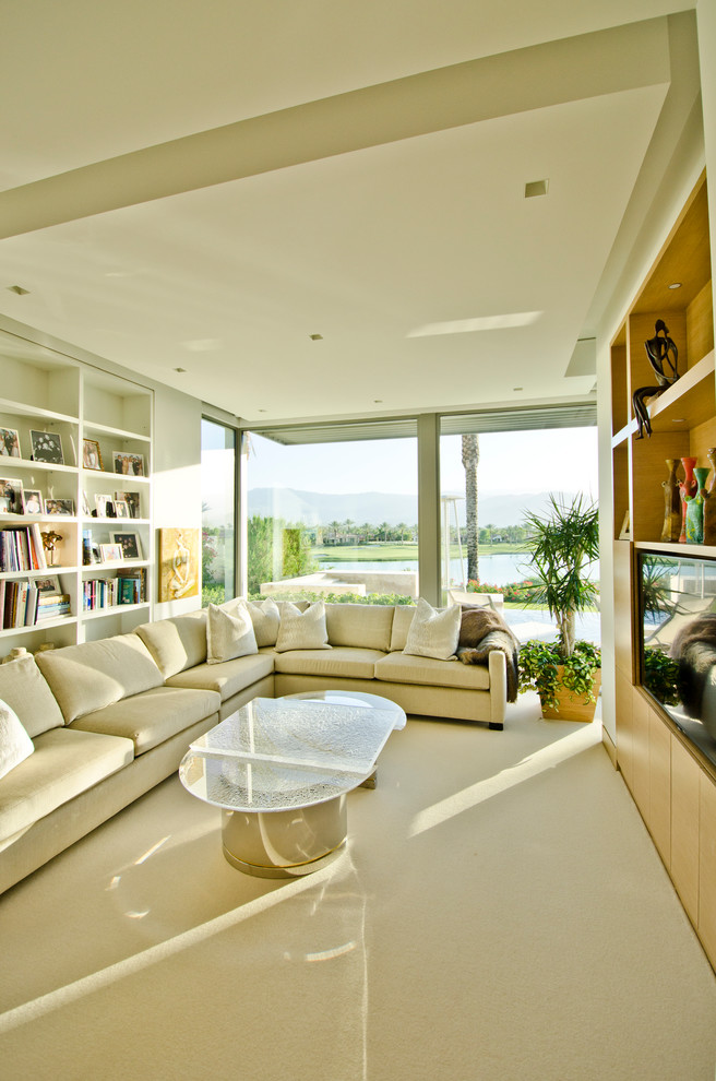 This is an example of a large enclosed living room in Orange County with white walls and a built-in media wall.