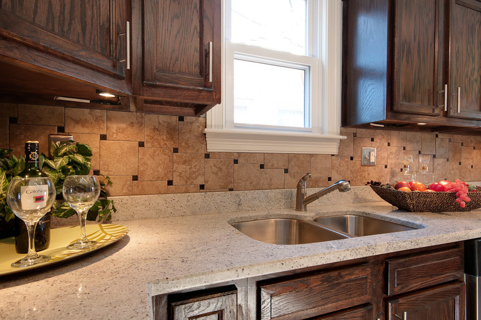 Inspiration for a mid-sized transitional u-shaped dark wood floor eat-in kitchen remodel in Nashville with a drop-in sink, recessed-panel cabinets, stainless steel appliances, no island, medium tone wood cabinets, marble countertops, multicolored backsplash and ceramic backsplash