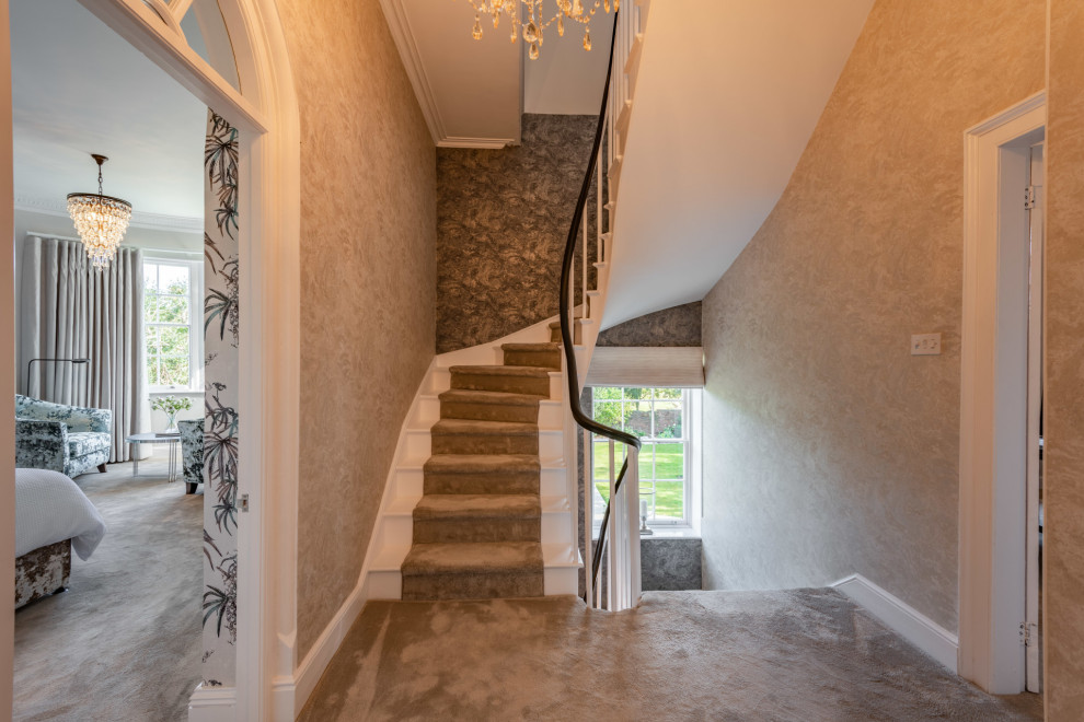 На фото: большой коридор в классическом стиле с бежевыми стенами, ковровым покрытием, серым полом и обоями на стенах