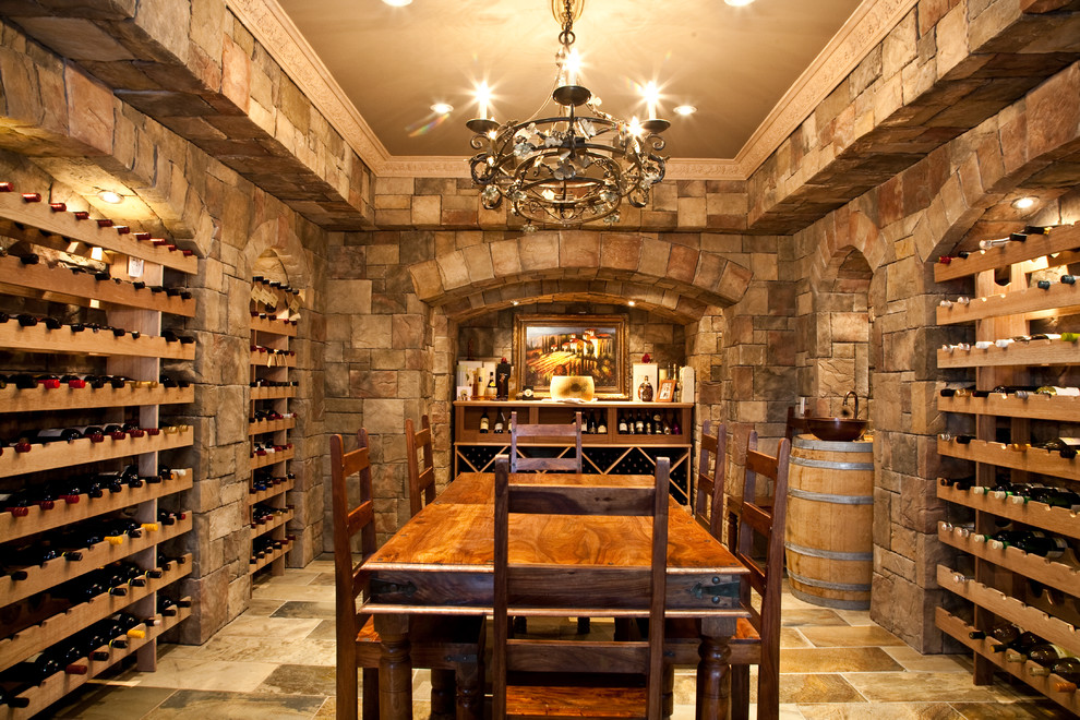 Photo of a large mediterranean wine cellar in Toronto with storage racks, terra-cotta floors and beige floor.