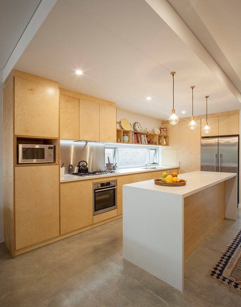Contemporary l-shaped kitchen in Sydney with flat-panel cabinets, light wood cabinets, glass sheet splashback, stainless steel appliances, concrete floors, with island and grey floor.