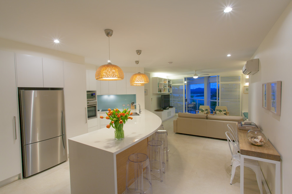 Photo of a contemporary open plan kitchen in Sunshine Coast with an undermount sink, quartz benchtops, blue splashback, glass sheet splashback, stainless steel appliances, ceramic floors and with island.