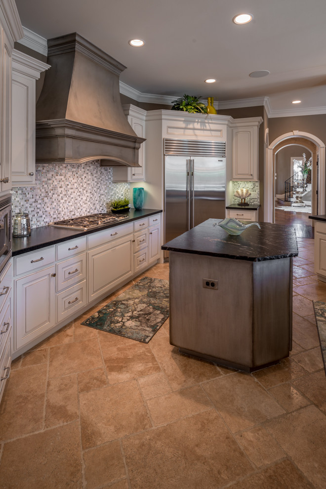 Example of a large transitional u-shaped travertine floor and beige floor open concept kitchen design in Houston with beaded inset cabinets, white cabinets, quartz countertops, metallic backsplash, ceramic backsplash, stainless steel appliances and two islands