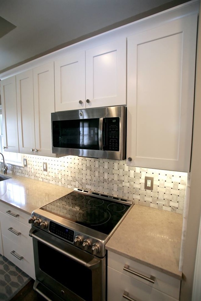 Large transitional l-shaped open concept kitchen photo in Cincinnati with a single-bowl sink, shaker cabinets, white cabinets, quartz countertops, white backsplash, marble backsplash, stainless steel appliances and an island